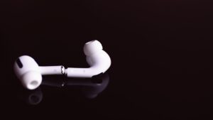 AirPods Pro 2 lying apart on a reflective black surface.