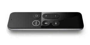 A modern black Apple TV remote control with a matte finish, featuring a circular menu button, a play/pause button, volume control, a microphone for voice commands, and a power button.
