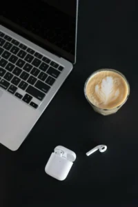 Apple AirPods 2 next to MacBook and coffee
