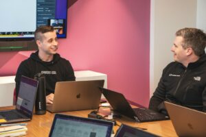 Two business professionals discussing top RFP management tools on a computer
