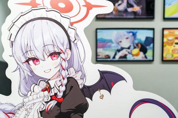 A woman with white hair and red eyes is standing in front of a wall with