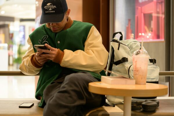 A man sitting on a bench looking at his cell phone