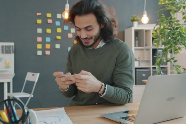 Man smiling while looking at his phone