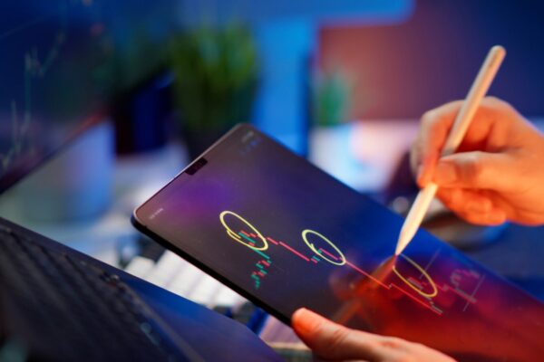 Someone is working on the tablet to analyze stock data.